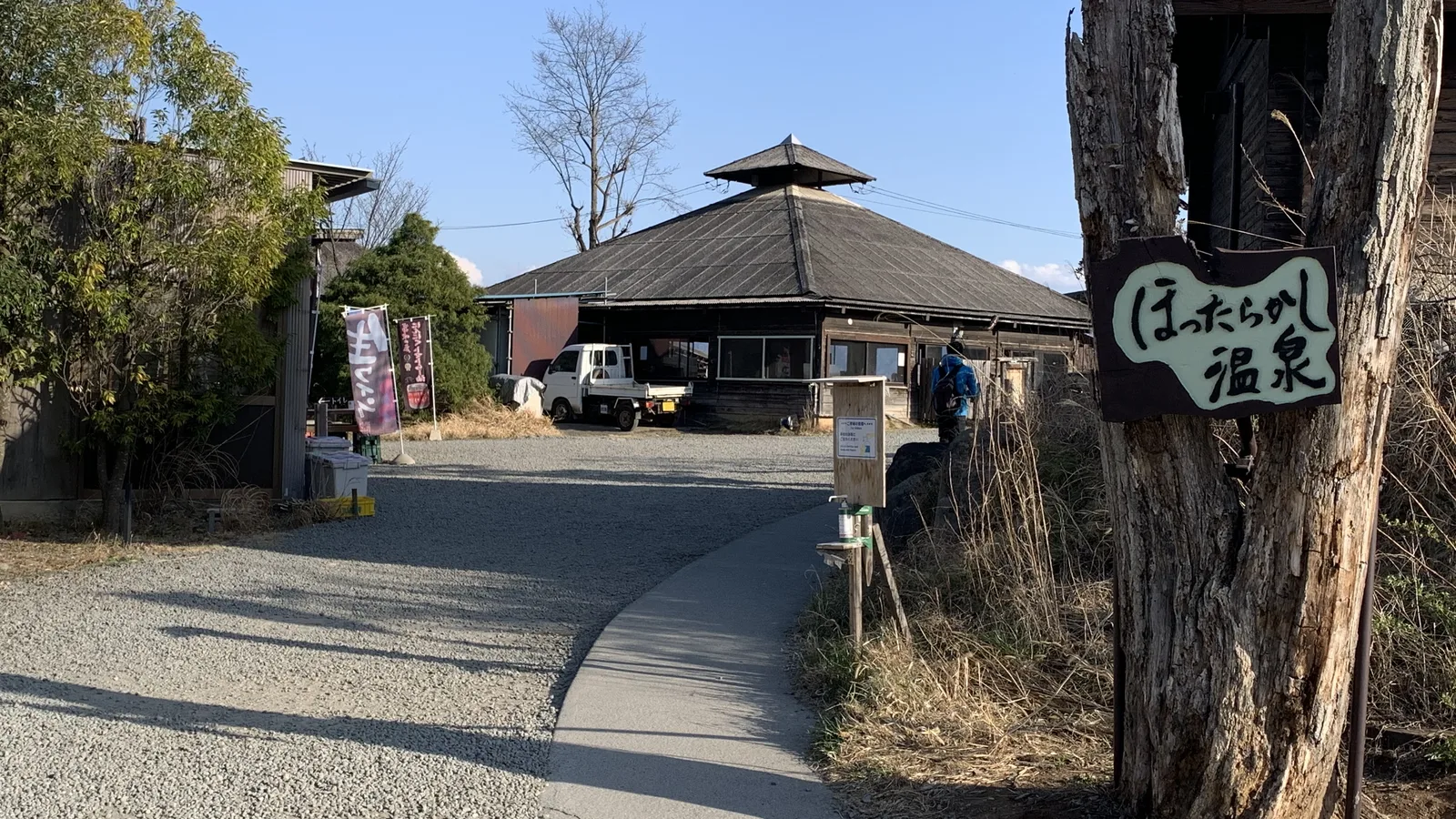 木製の看板と建物が見えるほったらかし温泉の入口